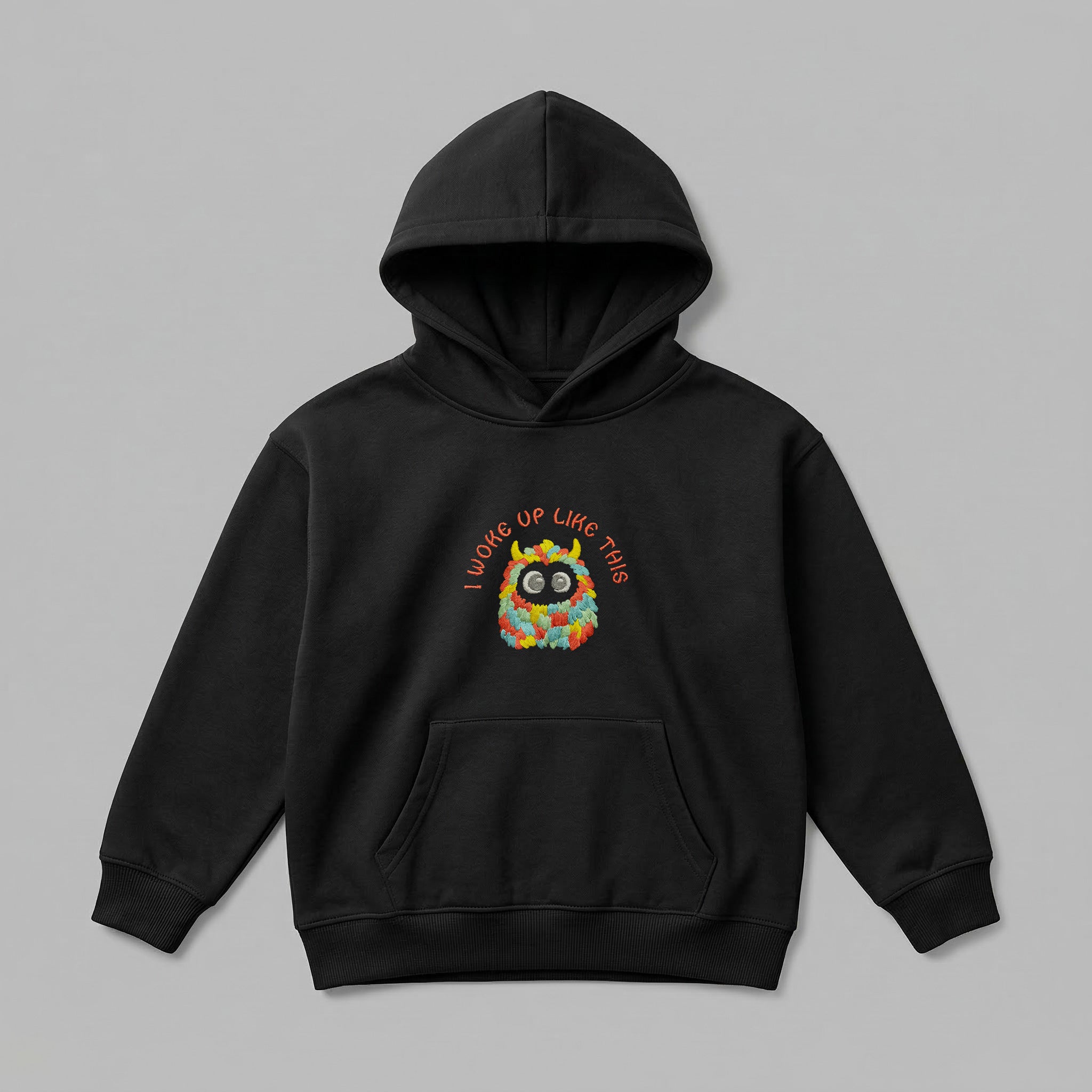 Siyah renkli, Oeko-Tex sertifikalı kalın polar çocuk kapüşonlu sweatshirt (hoodie). Göğüs kısmında canlı renkli tüylü canavar figürü ve uyumlu renkte iplikle işlenmiş "I WOKE UP LIKE THIS" nakışı bulunur. İçi şardonlu dokusu kışın sıcak tutarken nefes alan yapısıyla terletmez. Fermuarsız tasarımı, kanguru cebi, fitilli trims ve birinci sınıf Alman nakış işçiliği ile üretilmiş, konforlu ve esprili premium kışlık çocuk üst giyim parçası.