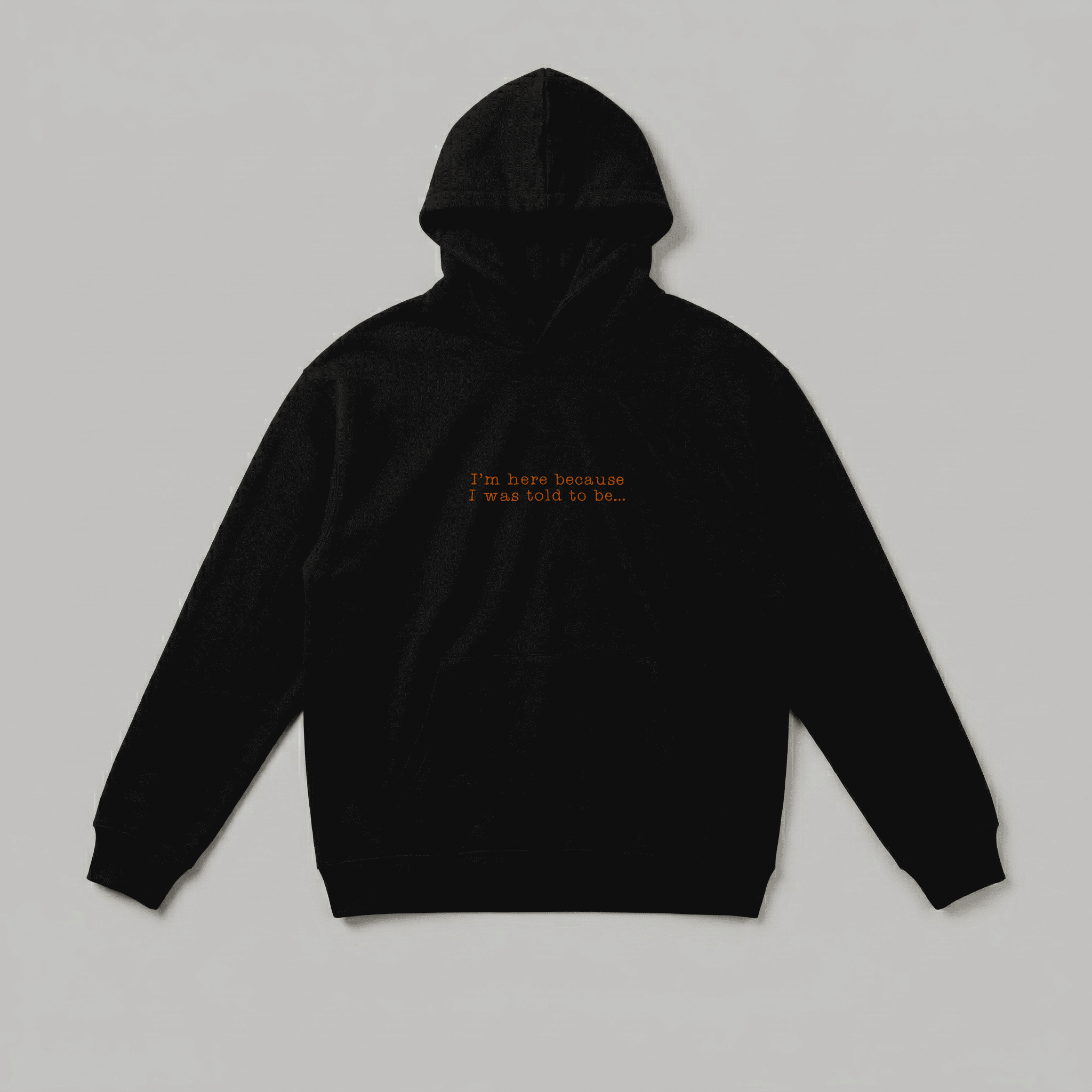 Siyah renkli, Oeko-Tex sertifikalı kalın polar erkek kapüşonlu sweatshirt. Göğsünde daktilo fontu ve kiremit rengi iplikle işlenmiş "I'm here because I was told to be..." nakışı bulunur. İçi şardonludur; sıcak tutar, rüzgarı keser ve terletmez. Kanguru cepli tasarımı ve yüksek kalite Alman nakış işçiliğiyle üretilmiş esprili, premium kışlık ürün.