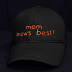 Siyah renkli, %100 pamuklu premium anne şapkası. Ön panelinde beyaz iplikle "Mom knows best!" yazısı ve küçük bir kalp nakışı, yüksek kalite Alman işçiliği ile işlenmiştir. Hassas ciltlere dost, nefes alan ve terletmeyen yapısıyla gün boyu konfor sunar. Anneler için esprili ve şık bir hediye seçeneği.