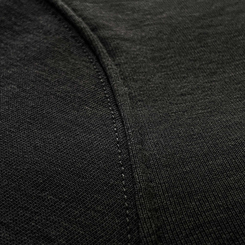 Siyah premium yetişkin hoodie (kapüşonlu sweatshirt) modelinin kol dikişi birleşimini ve tok pamuklu kumaş dokusunu gösteren makro detay çekimi. Ağır gramajlı (heavyweight) kumaşın yoğun örgüsü ve pürüzsüz yapısı üzerine uygulanmış sağlam, temiz dikiş işçiliği ön plana çıkmaktadır. Dayanıklılığı, premium hissi ve kusursuz yapım kalitesini vurgulayan yakın çekim.