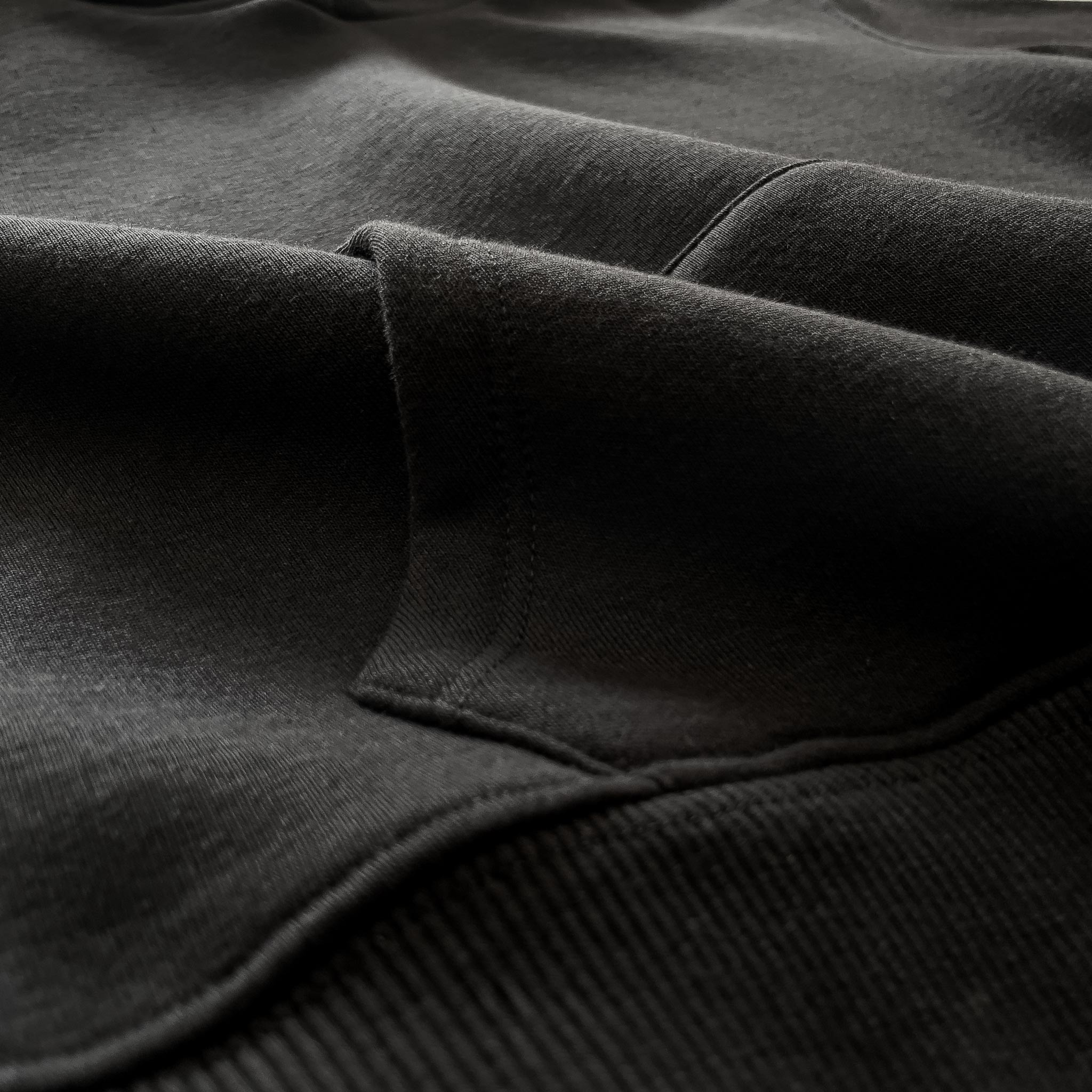 Siyah renkli çocuk sweatshirt modelinin formunu koruyan kalın fitilli etek ucu ribanasını ve kusursuz alt dikiş işçiliğini gösteren detay fotoğrafı. Beli tam kavrayarak vücut ısısını koruyan, ancak esnek yapısıyla oyun sırasında çocuklara rahatsızlık vermeyen ergonomik ve dökümlü tasarım. Oeko-Tex standartlarına uygun kalın kışlık kumaşıyla bu kapüşonlu üst, soğuk havalarda maksimum koruma sağlayan kaliteli çocuk giyim ürünleri arayan aileler için rüzgar geçirmeyen dayanıklı bir seçenektir.