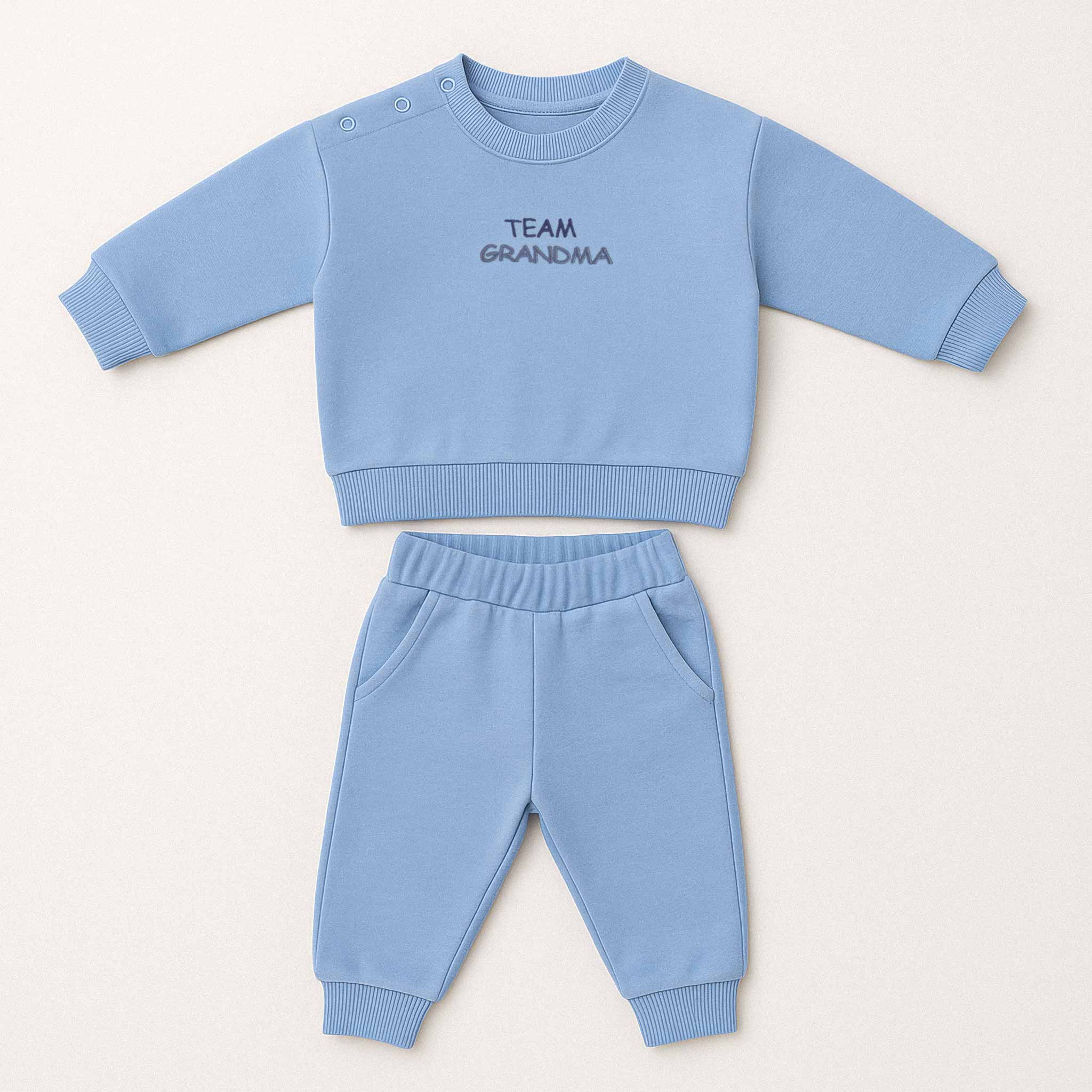 Mavi renkli, sweatshirt ve pantolondan oluşan "Team Grandma" nakışlı, omuzdan çıtçıtlı pamuklu bebek eşofman takımı.