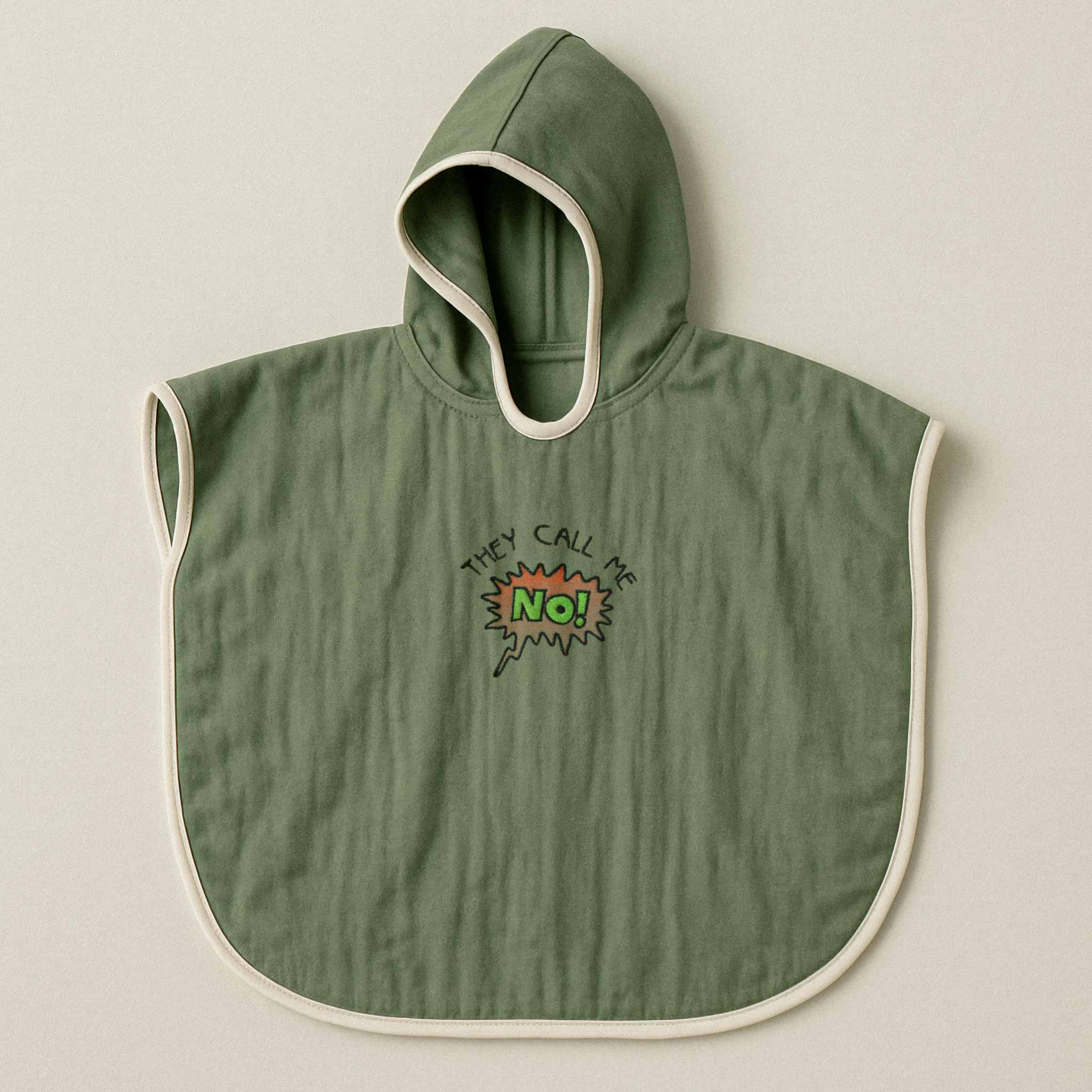 Haki yeşili renginde, kapüşonlu, müslin kumaştan bebek ve çocuk pançosu. Göğüs kısmında çizgi roman stilinde "THEY CALL ME NO!" yazısı işlenmiştir.