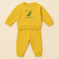 Hardal sarısı renkli, sweatshirt ve pantolondan oluşan, üzerinde sevimli bir T-Rex dinozoru ve "Tiny Arms Big Dreams" baskısı bulunan, omuzdan çıtçıtlı pamuklu bebek eşofman takımı.