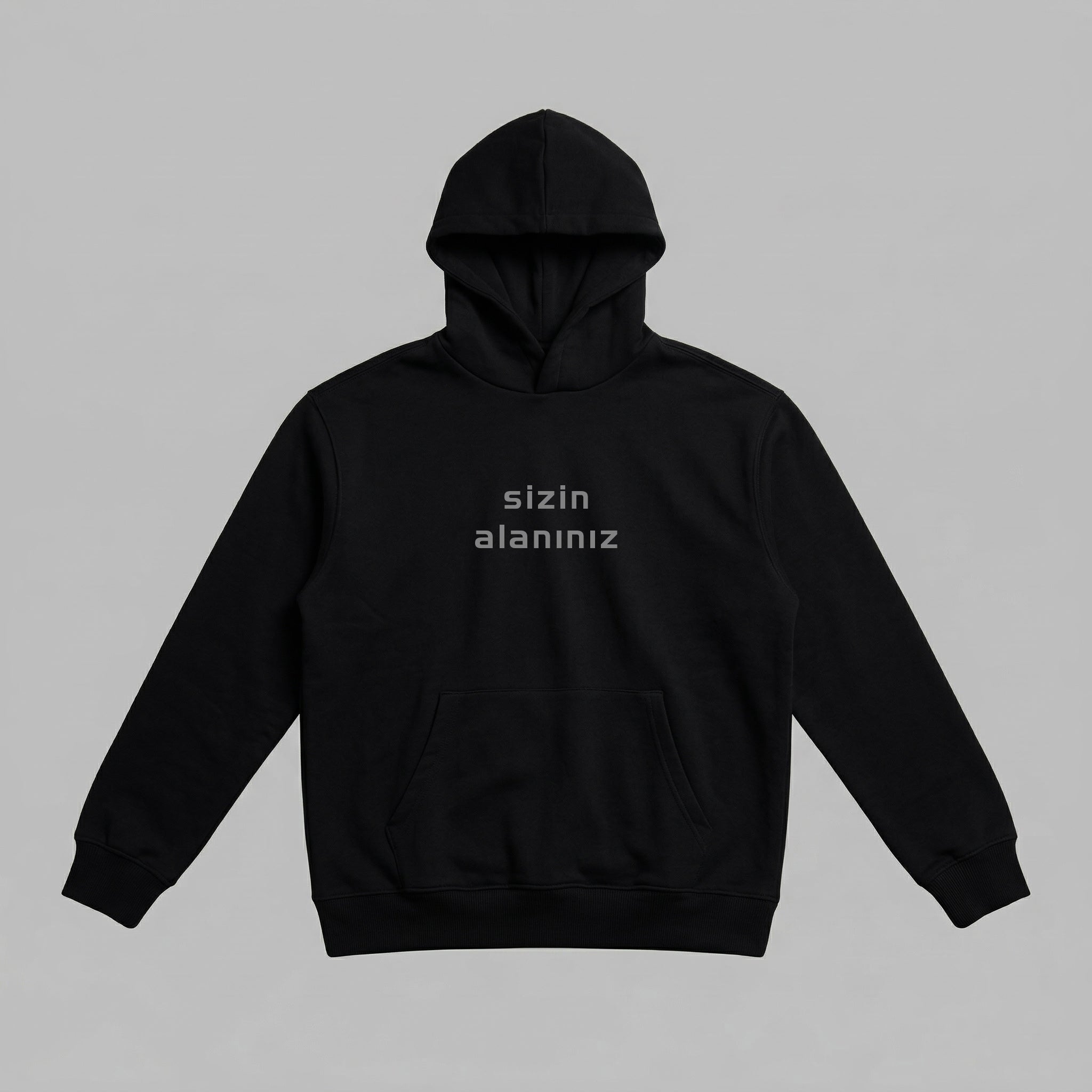Yetişkinler için siyah renkli, premium oversize kapüşonlu sweatshirt. Göğüs kısmındaki "sizin alanınız" yazısı, kişiye özel isme veya tasarıma özel Alman nakış işlemesinin uygulanacağı konumu gösterir. %100 pamuklu, Oeko-Tex sertifikalı heavyweight kumaşı, soğuk günlerde sıcak tutarken yumuşacık dokusuyla cildi terletmez. Kanguru cebi ve esnek ribana manşetleri ile gün boyu konforlu ve şık bir kullanım sunar. Sağlıklı ve kişisel bir premium giyim ürünüdür.